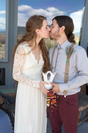 Newly weds hold traditional wedding vase and hand fasting sash at wedding at SpiriTaos