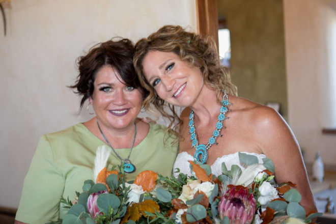 Chasity and her maid of honor smile before the outdoor summertime wedding