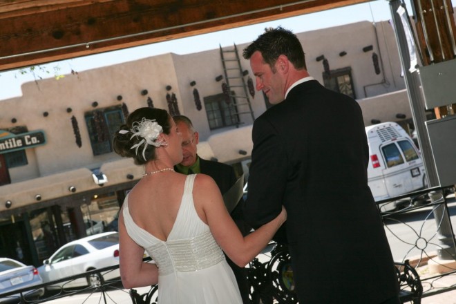 The bride and groom steal a quick look at one another during their Taos plaza wedding