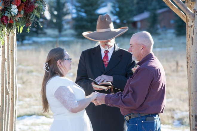 Celeste and Joe smile and hold hands during their autumn wedding