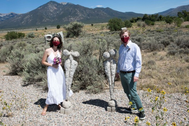 Masks, art, boobs, bride, groom, a field of sagebrush and Taos mountains