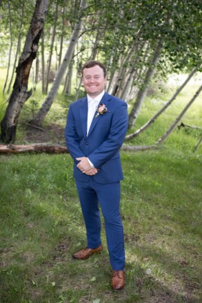 Clynt, in a blue suit, has photos taken while he's waiting for his wedding ceremony