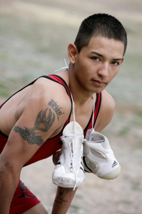 High school senior poses with his tattoo and wrestling gear