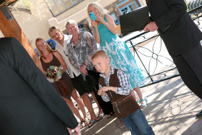 The ring bearer offers the rings at this springtime Taos wedding ceremony