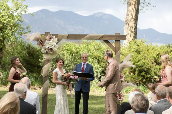 Bride and groom share a laugh with the minister during the ceremony