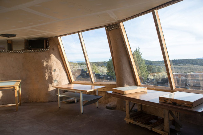 Earthship artist studio with windows looking out at Taos mesa