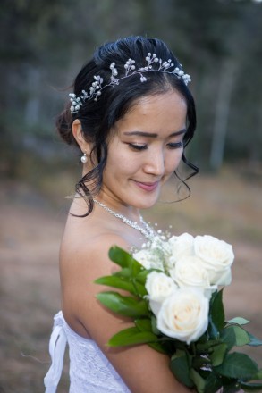 Chisato holds white roses on her wedding day near Angel Fire, NM