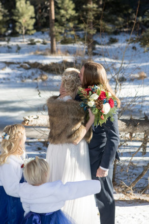 Kyle kisses Amberly after their Red River wedding, their daughters look on.