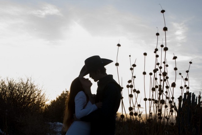 Bride and groom silhouetted by Taos' evening light