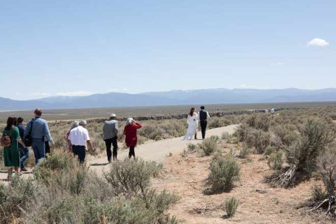 Small group of Texans attending small outdoor wedding ceremony by Taos gorge bridge