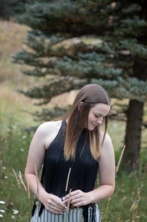 Katie poses with tall grass and ponderosa pine in Red River, NM