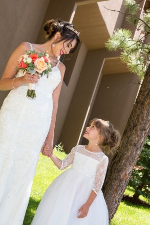 Monica smiles at her flower girl before the outdoor Angel Fire wedding.