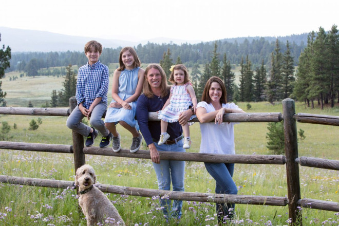 Family on vacation has photos taken on fence in Angel Fire with dog