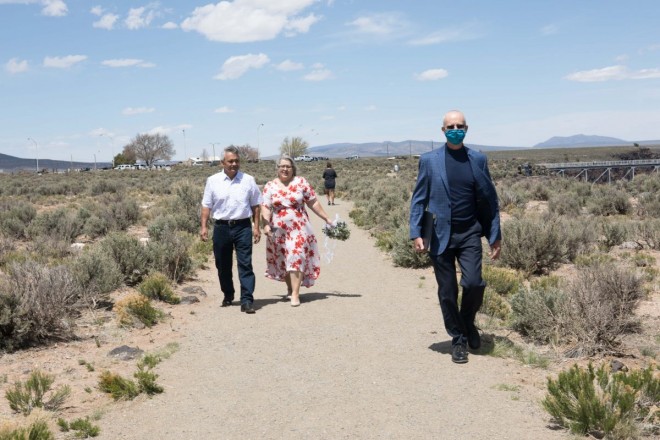 Wedding officiant, Dan Jones, leads Steven's parents out to the wedding site on the Taos mesa