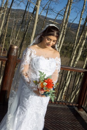 Alysa smiles as she looks at her wedding bouquet during her Angel Fire bridal portraits