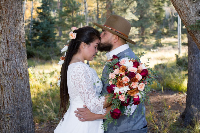 Edwardo kisses Sarah next to ponderosa pine trees