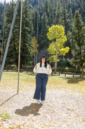 Katy wears a black hat as she takes a swing for her Red River senior pictures