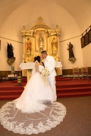 A wedding kiss at the altar at Our Lady of Guadalupe Parish in Antonito, CO