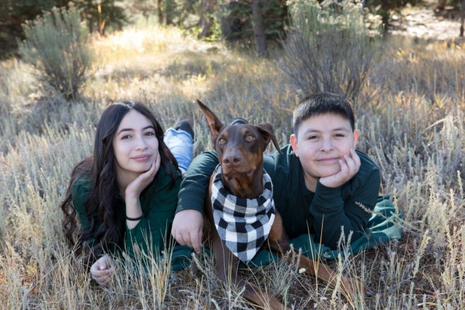 Brother and sister pose with dog during family photos