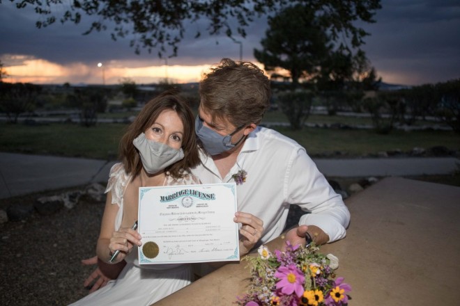 Erin and Cory with masks and New Mexico marriage license signed by officiant Dan Jones