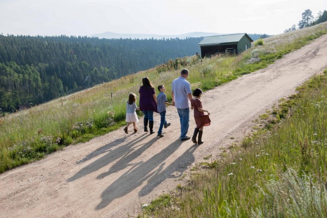 Family enjoys walk on mountain road near sunset in Red River