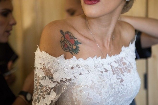 Sisters tattoo showing above bride's wedding dress