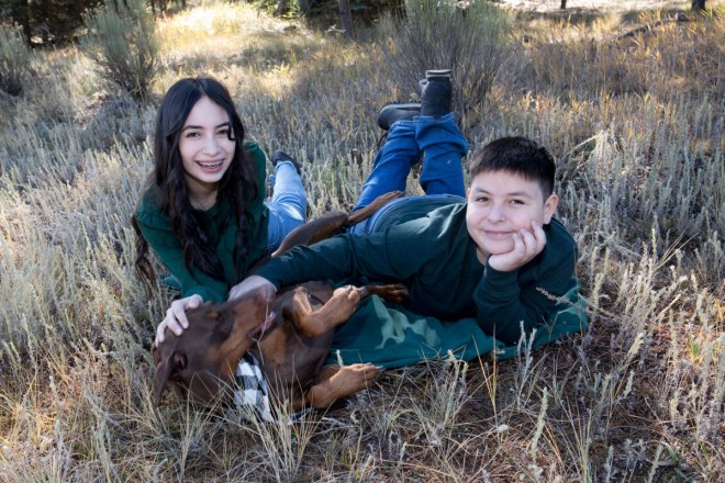 Brother and sister pose with dog-siblig
