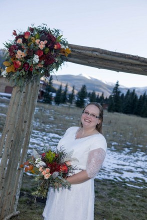 Bride in Red River holds her bouquet with snow on ground in background