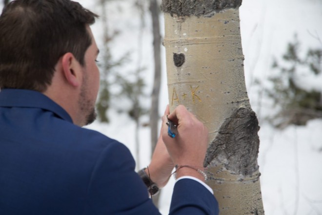 Andrew carves their initials into the aspen tree bark as a forever Taos Ski Valley memento