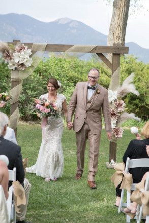 Lindsay and John walk down the aisle overlooked by Taos Mountain