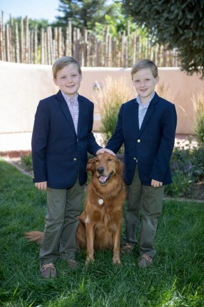 Twin 8-year-old boys have their picture taken with their dog-brother