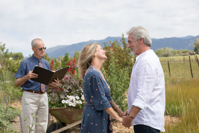 Susan and JR say their wedding vows with silhouette of Sangre de Cristo Mountains in background.