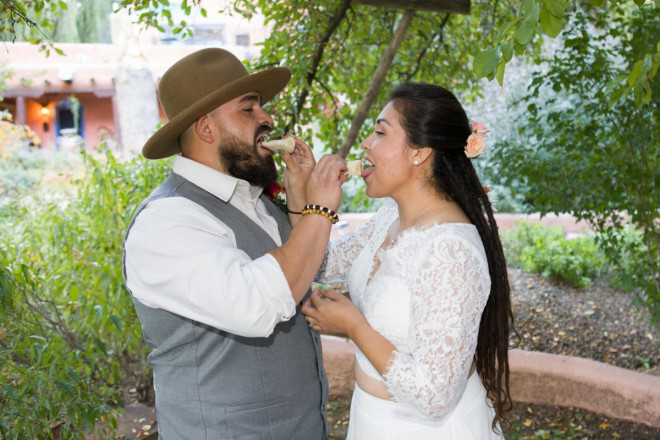 Sarah and Edwardo feed each other cake on their wedding day