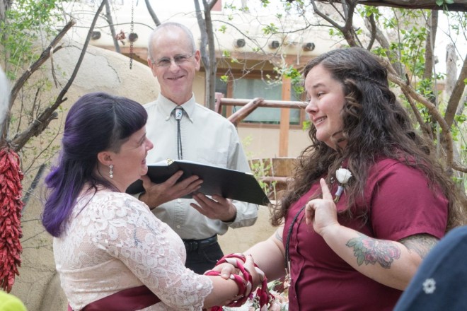 Officiant, Dan Jones, smiles as Kelsey and April say their vows