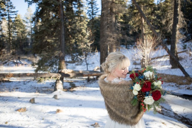 Beautiful blonde bride views her professional wedding bouquet in Red River, NM