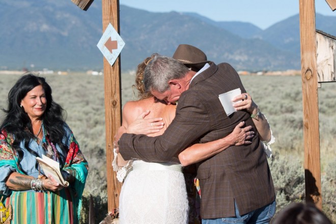 Chasity and Bill hug their best friend and wedding speaker as officiant watches