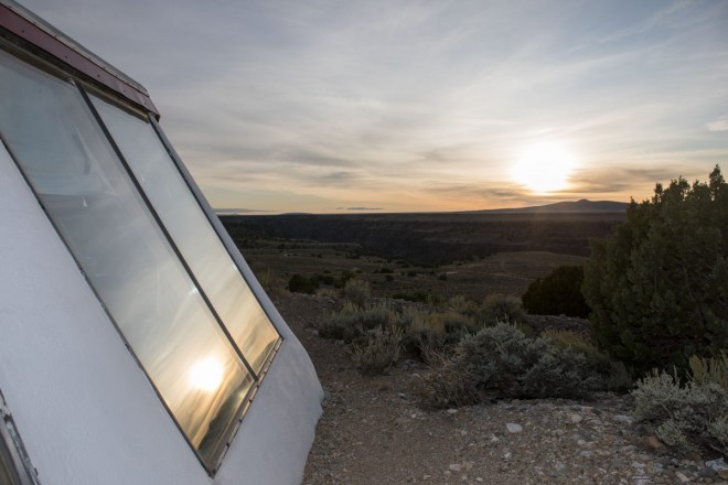 Reflection of simple sunset in Earthship windows on Hondo mesa
