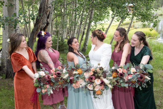 Smiling bridesmaids show off their bouquets before the wedding ceremony