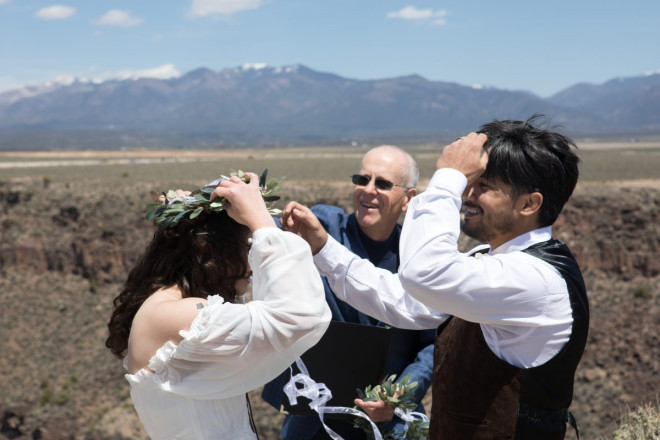 Beautiful bride and groom share smiles with their officiant during their customized wedding ceremony