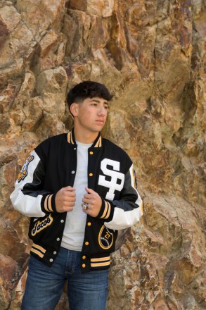 Jacob holds his Letterman's jacket during his Red River senior photo shoot