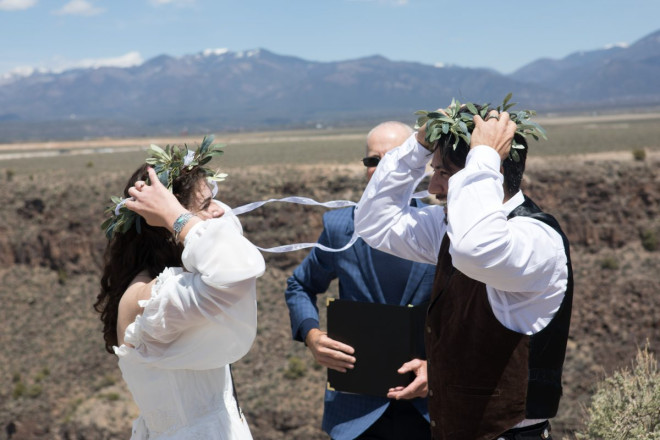 Mackenzie and Steven laugh as the wind almost took their crowns made of leaves, into the gorge at their cliff-side wedding ceremony