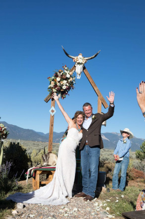 Chasity and Bill raise their hands in achievement after their northern New Mexico wedding