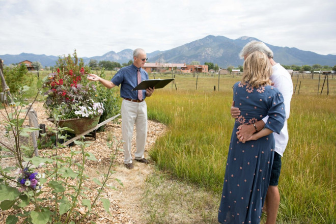 Minister, Dan Jones, blesses the rings at private wedding ceremony in Taos, NM