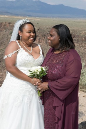 Cynthia and her mom look at each other and laugh before the wedding cermeony