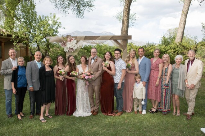 Lindsay and John and their wedding guests in front of Taos mountain