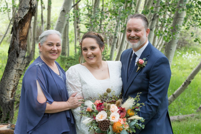 Scarlett stands with her parents for a formal photos with flowers