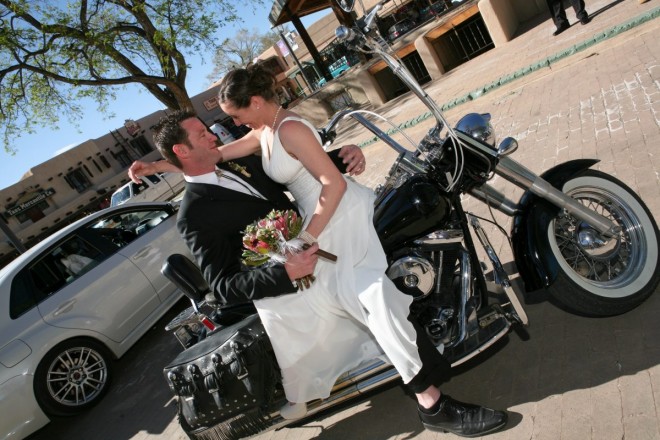 This groom loves his bride and his motorcycle and made sure both were included in their Taos wedding photos