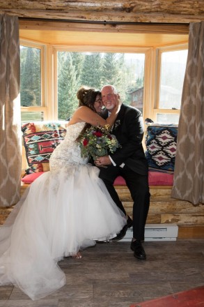 Barefoot bride cuddles up to her husband in the window seat at their Red River cabin rental