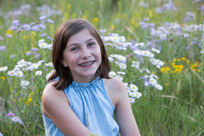 Tween girl poses for school picture with wildflowers