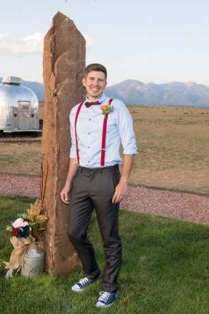 Stephen at wedding altar with mountains and silver trailer
